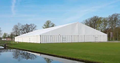 Zelt als Lagerhalle: Effektive Möglichkeit zur temporären Lagerung von Waren auf einer Wiese oder im Freien. Schützt das Inventar vor Witterungseinflüssen und sorgt für eine trockene und sichere Lagerung.